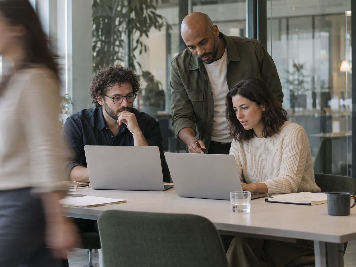 Beratungsteam arbeitet gemeinsam an Laptops in einem modernen Büro